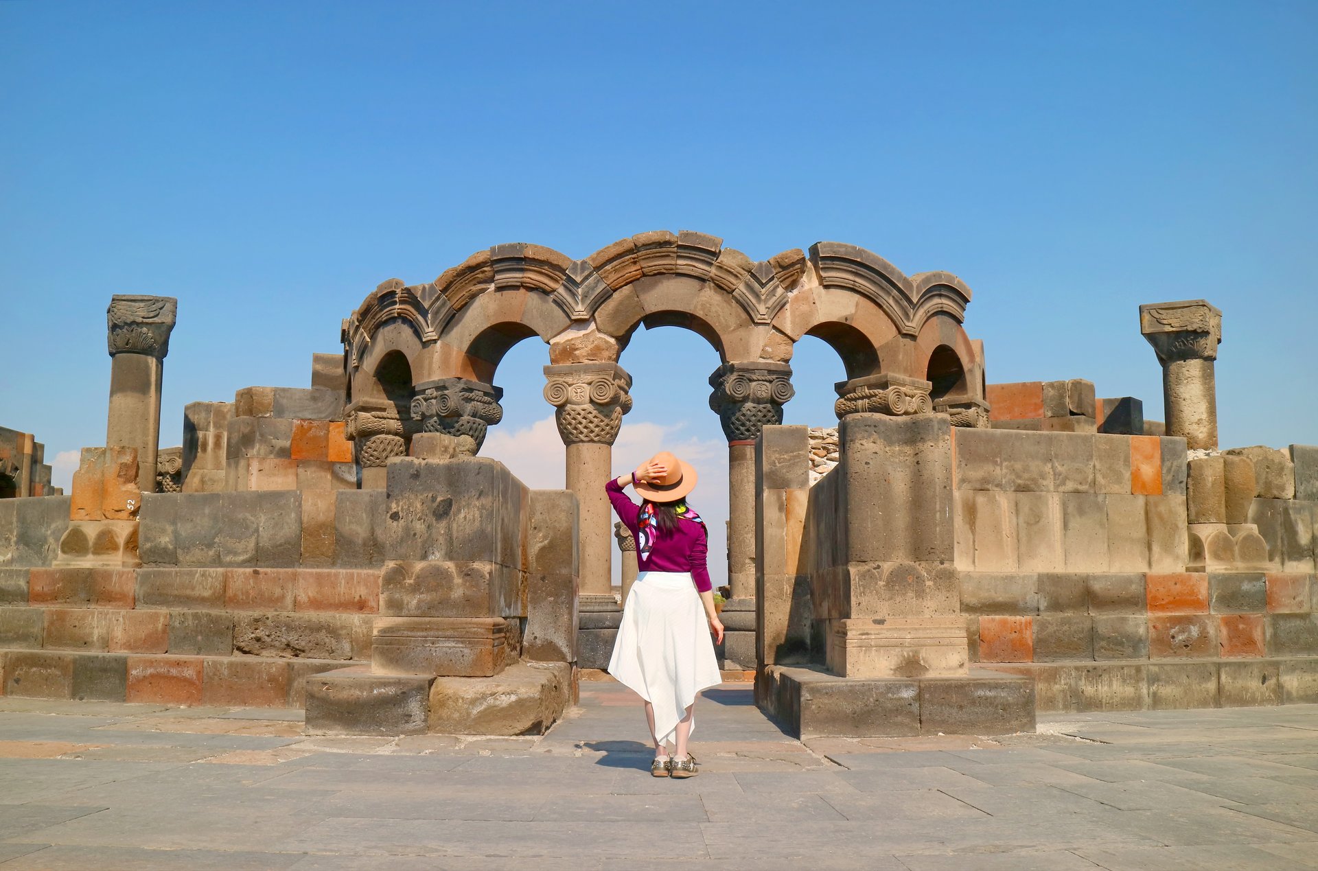 Femme devant la cathédrale Zvartnots, province d'Armavir, Arménie