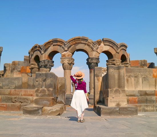 Femme devant la cathédrale Zvartnots, province d'Armavir, Arménie