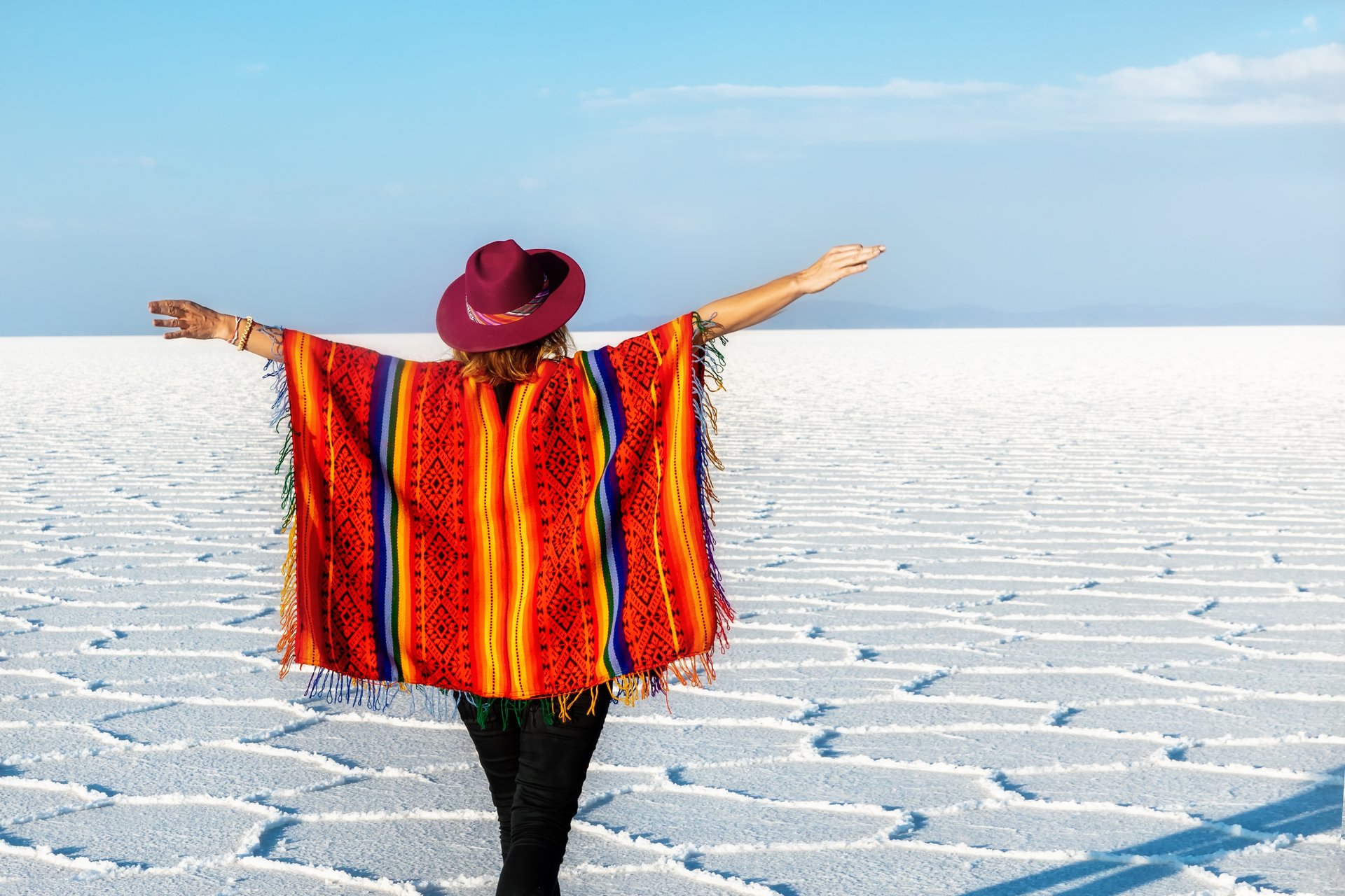 Une fille en chapeau et en poncho devant le Salar d'Uyuni, Bolivie