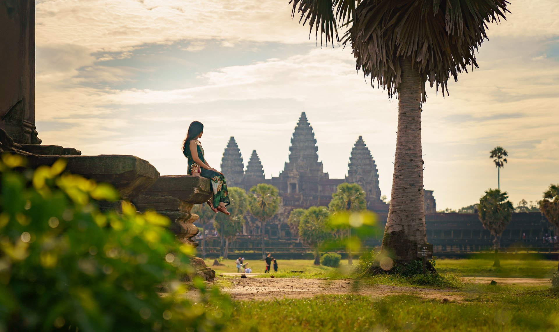 Femme assise sur un rocher devant le temple d'Angkor Wat, Cambodge