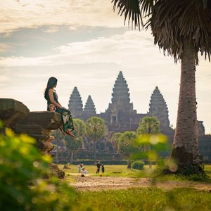 Femme assise sur un rocher devant le temple d'Angkor Wat, Cambodge