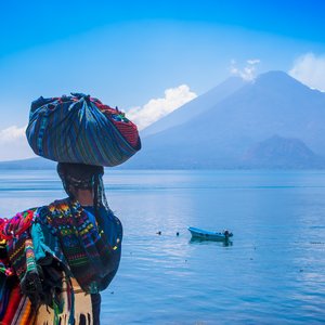Une femme en tenue traditionnelle de dos devant le lac Atitlan, Guatemala