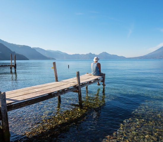 Touriste assis devant le lac Atitlan au Guatemala