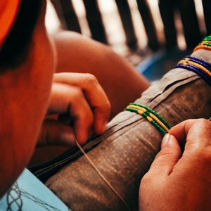 Femme en train de confectionner des bracelets sur San Blas au Panama