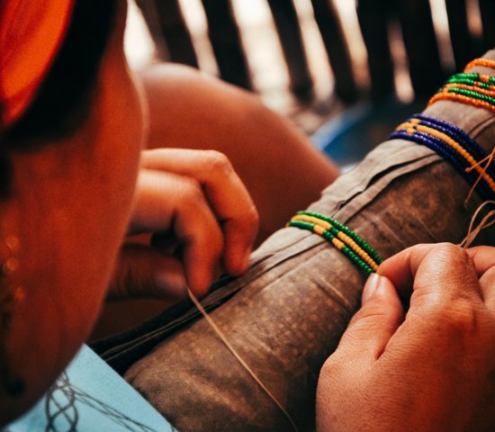 Femme en train de confectionner des bracelets sur San Blas au Panama